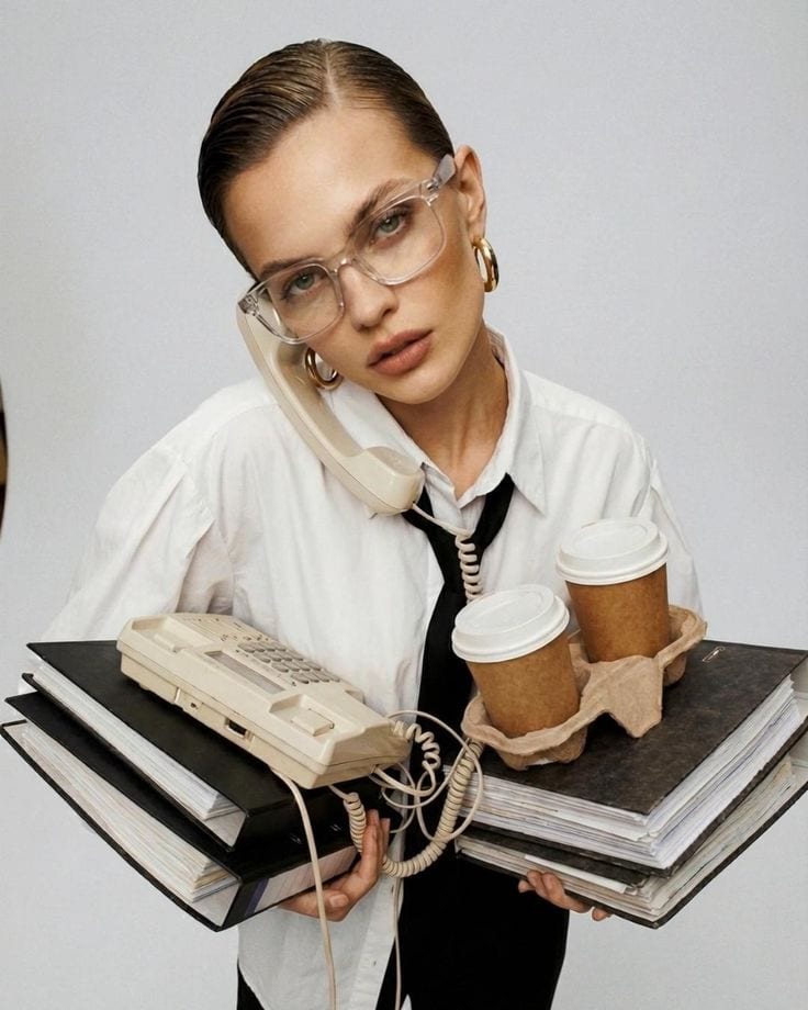 Someone holding a phone, coffees and folders all at once