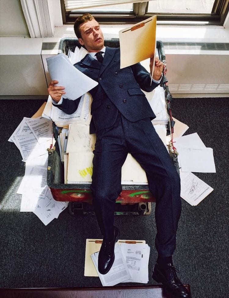 A professional surrounded by paperwork in mid-air, weighing the options