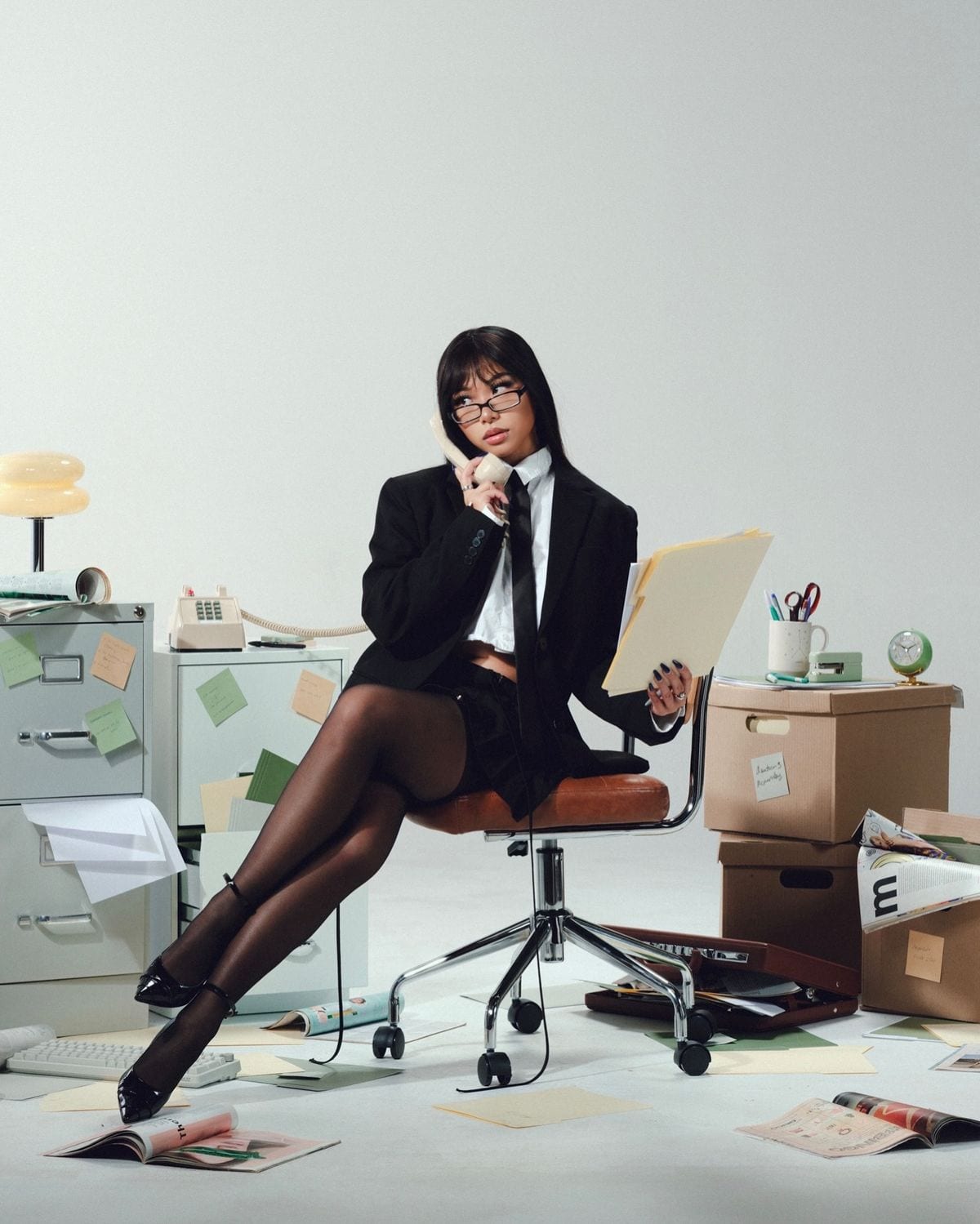 An administrator on the phone surrounded by filing cabinets and folders