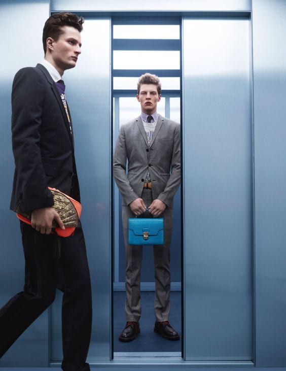 Two professionals in a lift with a secured briefcase